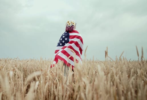 Patriot woman standing with american national flag in rural wheat field landscape. Symbol of democracy, independence, USA, 4th July celebration, US banner, memorial Veterans, election, America, labor