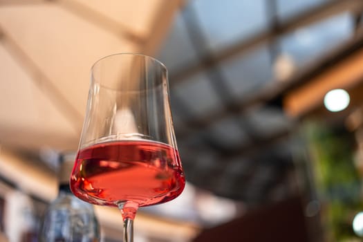 Close-up of a glass of rose red wine on an outdoor table. The relaxed ambiance and vibrant colors reflect the city s lively dining culture and Mediterranean lifestyle.