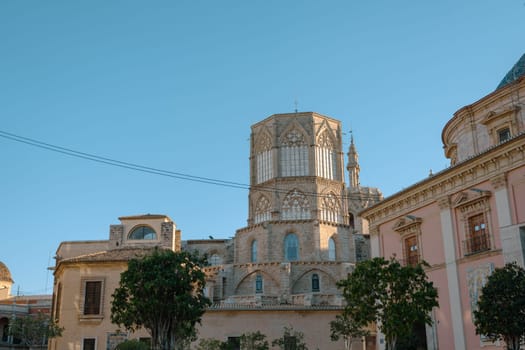 Historic building with intricate architectural details and a clear blue sky in Valencia. The structure stands out against the bright background, emphasizing its historical significance.