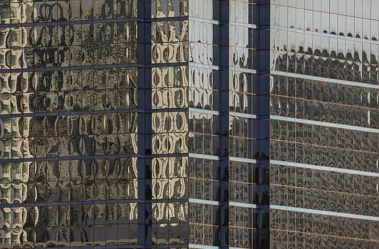 Bangkok, Thailand - 22 Jun, 2024 - Architectural exterior of modern office building facade with blue sky and clouds reflection in windows. Steel frame and glass windows architecture, Space for text, Selective focus.