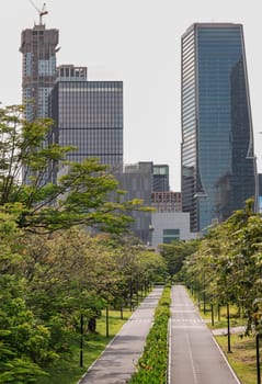 Bangkok, Thailand - 22 Jun, 2024 - The large urban park with trails for running and cycling serene atmosphere with Modern high-rise buildings and sky background. Space for text, Selective focus.