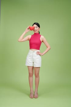 Beautiful woman hold red heart, isolated on green background