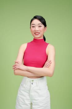 A confident woman poses against a green background, embodying summer style and casual fashion.