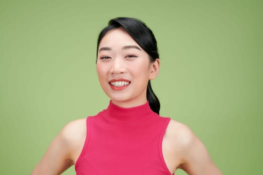 Confident Woman in Pink Top Against Green Background
