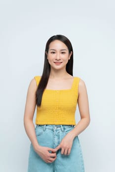 Smiling Young Woman in Yellow Top Against White Background