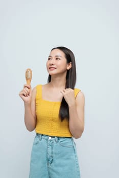 A relaxed woman brushing her long hair while enjoying a moment of self-care