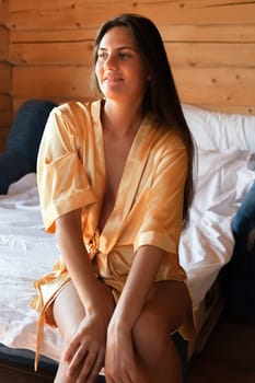 Camping holiday. Portrait of a young woman in a dressing gown in the early morning in a wooden cottage at a campsite