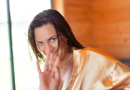 Camping holiday. Portrait of a young woman in a dressing gown in the early morning in a wooden cottage at a campsite