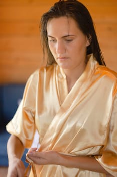 Camping holiday. Portrait of a young woman in a dressing gown in the early morning in a wooden cottage at a campsite