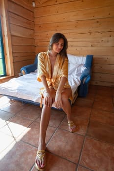 Camping holiday. Portrait of a young woman in a dressing gown in the early morning in a wooden cottage at a campsite