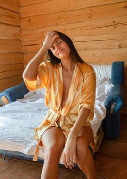 Camping holiday. Portrait of a young woman in a dressing gown in the early morning in a wooden cottage at a campsite