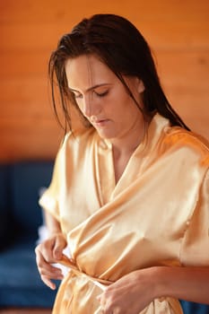Camping holiday. Portrait of a young woman in a dressing gown in the early morning in a wooden cottage at a campsite
