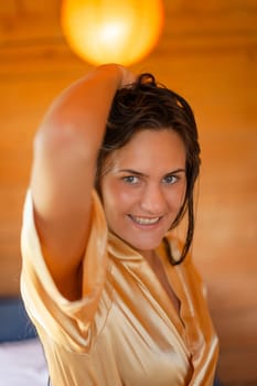 Camping holiday. Portrait of a young woman in a dressing gown in the early morning in a wooden cottage at a campsite