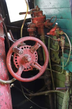 Vertical photo Steam engine controls. Fragment of the driver's cabin of a retro steam locomotive with steam engine controls, taps, valves, pipes, controls.