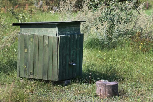 Abandoned bee hives in nature. Wooden beehives for bees on green grass in nature.