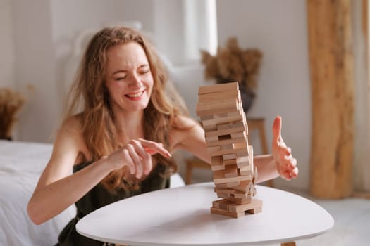 two women playing Jenga board game at home, excitement and relaxation, mind development concept, girl hands playing wooden game Django