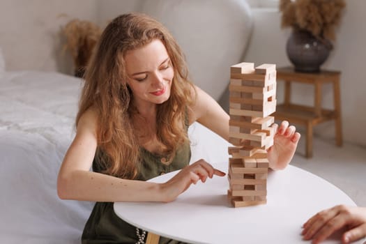 two women playing Jenga board game at home, excitement and relaxation, mind development concept, girl hands playing wooden game Django