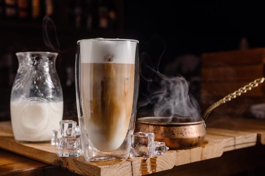 coffee drink with cream and ice on a dark wooden background, cold tonic drink coffee