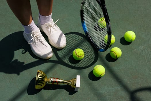 young female tennis player celebrating victory on the court, close-up of cup and tennis racket, victory in tennis tournament