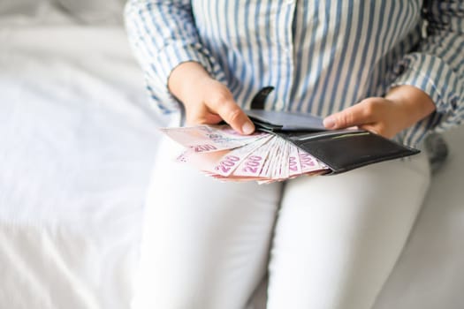 Leather wallet with money in the hands of a woman. Close-up of a woman taking a Turkish lira with a fan from her wallet, a lot of money but little value,high inflation rate in Turkey