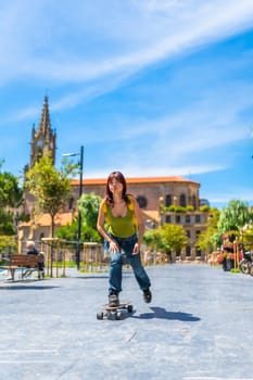 Vertical full length photo of a young chinese casual woman skateboarding on a city square