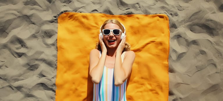 Summer vacation, tourism, happy cheerful young woman listening to music lying on sand on the beach, relaxed tourist girl in headphones on towel in swimsuit, glasses, sunny day, top view