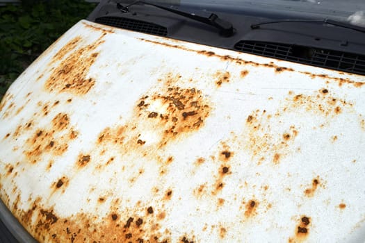 Fragment of car hood with rust