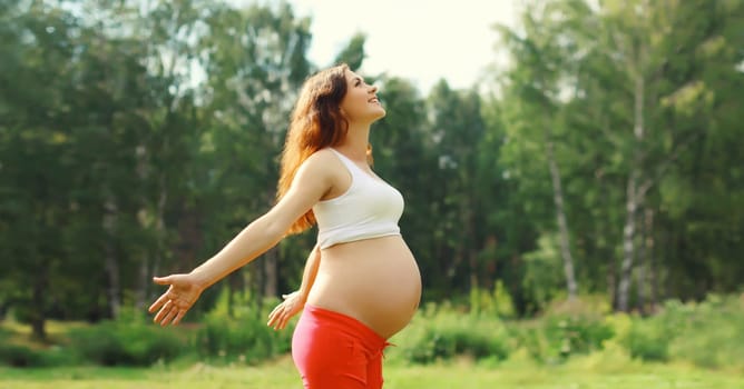 Maternity, pregnancy, happy young pregnant woman enjoying warm sunny day in summer park