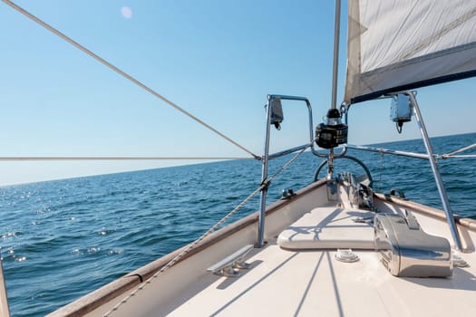 Luxury cruise on a sailing rigged yacht under a genoa sailing in a light wind during the regatta. Yachting as a luxury sport and great vacation. View from the deck to the bow, mast, sails. Gulf of Finland