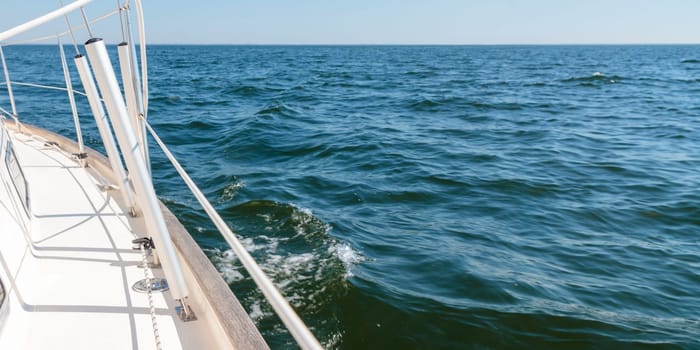 Banner with sailing in an open sea with waves. View to the side deck. Classic sailboat. Turnbuckles covers. Summer adventure, recreation, cruise, vacations, regatta, sport in Finland, Gulf of Finland.
