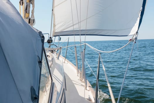 Luxury cruise on a sailing rigged yacht under a genoa sailing in a light wind during the regatta. Yachting as a luxury sport and great vacation. View from the deck to the bow, mast, sails. Gulf of Finland