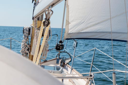 Luxury cruise on a sailing rigged yacht under a genoa sailing in a light wind during the regatta. Yachting as a luxury sport and great vacation. View from the deck to the bow, mast, sails. Gulf of Finland