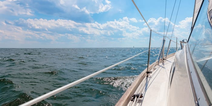 Banner with sailing in an open sea. View to the side deck. Classic sailboat. Summer adventure, recreation, cruise, vacations, regatta, sport in Finland, Gulf of Finland