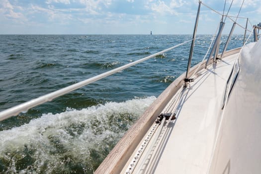 Banner with sailing in an open sea with waves. View to the side deck. Classic sailboat. Summer adventure, recreation, cruise, vacations, regatta, sport in Finland, Gulf of Finland.