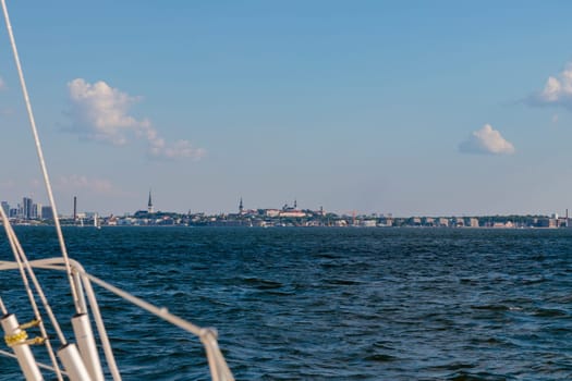 Luxury cruise on a sailing rigged yacht under a genoa sailing towards a shore. City, town on coastline, Tallinn, Estonia, Gulf of Finland, summer sailing