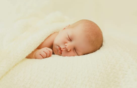 Close up portrait of sweet baby, infant sleeping lying on white bed at home