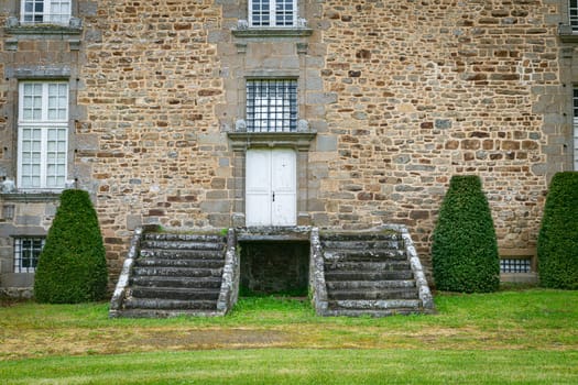old stairs in front of a castle wall and door