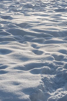 Brightly lit snow surface with footprints.