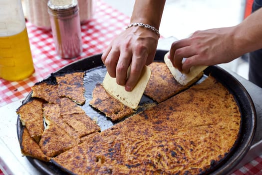 Socca, just coming out of the oven, in Nice, the French Riviera. Traditional street food in Nice, France.