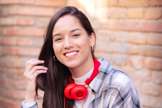 Attractive confident Caucasian teenage student looking at camera outdoors. Girl standing with happy face.