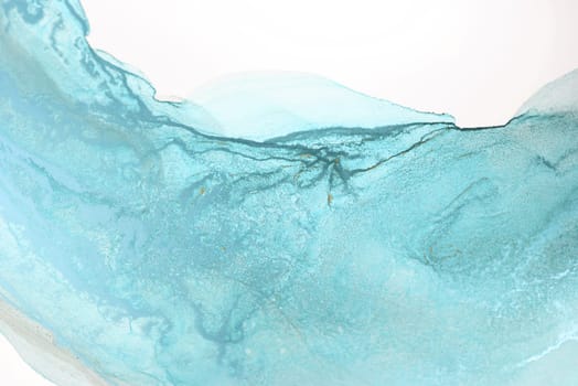 A close-up shot of a blue ink swirl on a white background, creating an abstract pattern.