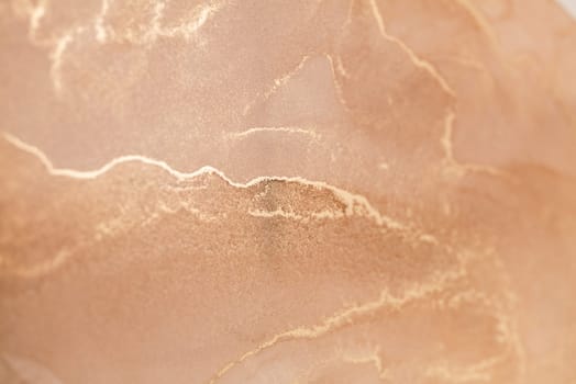 A close-up photograph showcasing a delicate abstract pattern of golden veins tracing across a soft, peachy background. This image evokes a sense of tranquility and warmth.