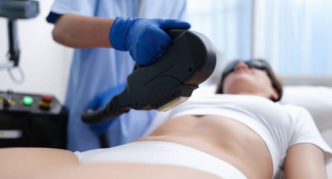 Cosmetologist removing unwanted hair from client body using laser closeup. Aesthetic medicine laser hair removal concept