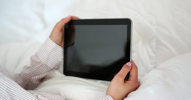 Close-up of woman holding tablet device with locked screen, turned off gadget. Tablet doesnt work, useless device. Mockup, technology concept. Copy space