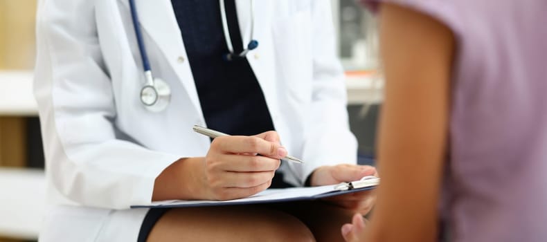Close-up of doctor in medical gown write down patient symptoms, medical appointment. Qualified worker examine patients history. Medicine, clinic concept