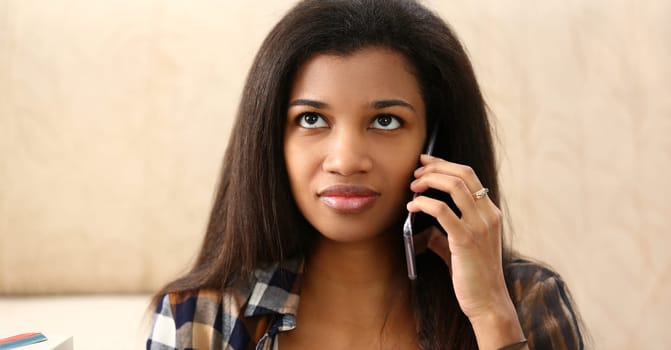 Portrait of beautiful latin woman chatting on mobile phone with friend, afro american female look away. Discuss news, happy to hear. Communication concept