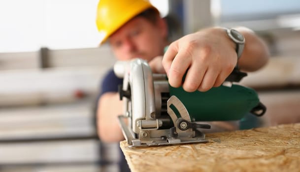 Close-up of male worker using electric saw tool, improvement on construction site, diy inspiration. Professional foreman work with wood, carpentry concept