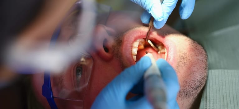 Portrait of dentist fixing damaged tooth, appointment in stomatology clinic, getting tooth fixed, reduce pain. Healthcare, stomatology, help, cure concept