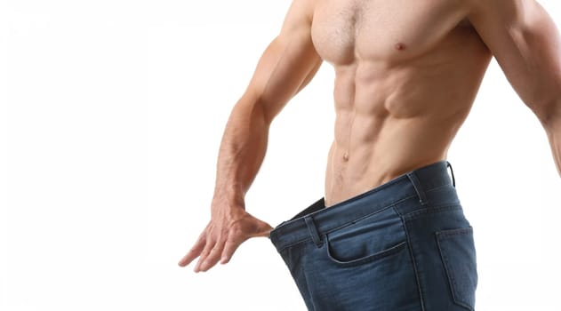 Close-up of strong fit man with muscle and six-pack abs, slim body, perfect figure, big pants. Fitness trainer, professional model. Sport, modeling concept
