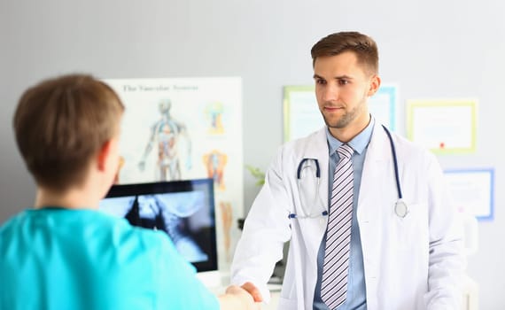 Portrait of specialist greeting colleague, friendly handshake gesture, intelligent doctor wear medical uniform. Medical conference, intern, health concept